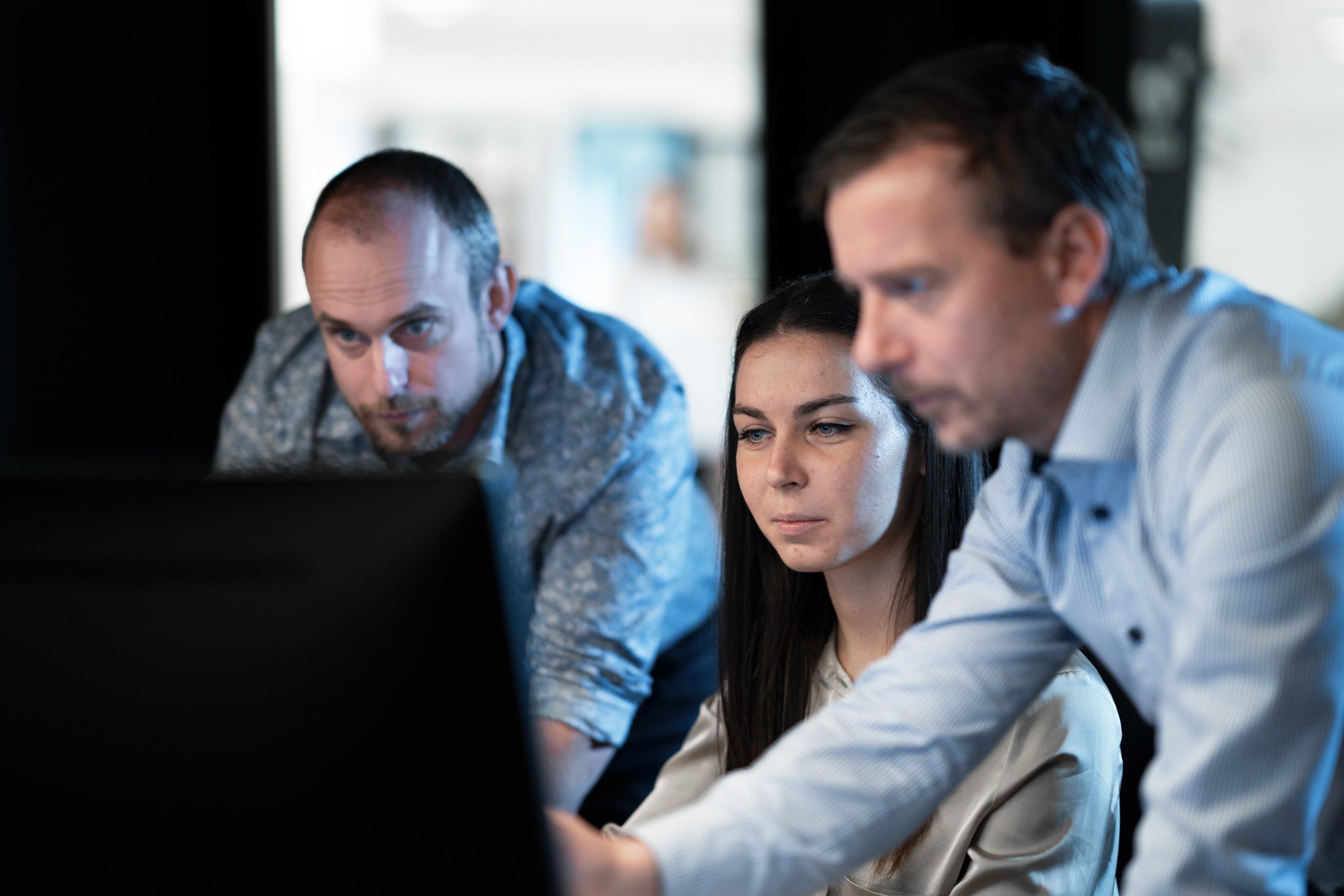 Employees in front of computer display