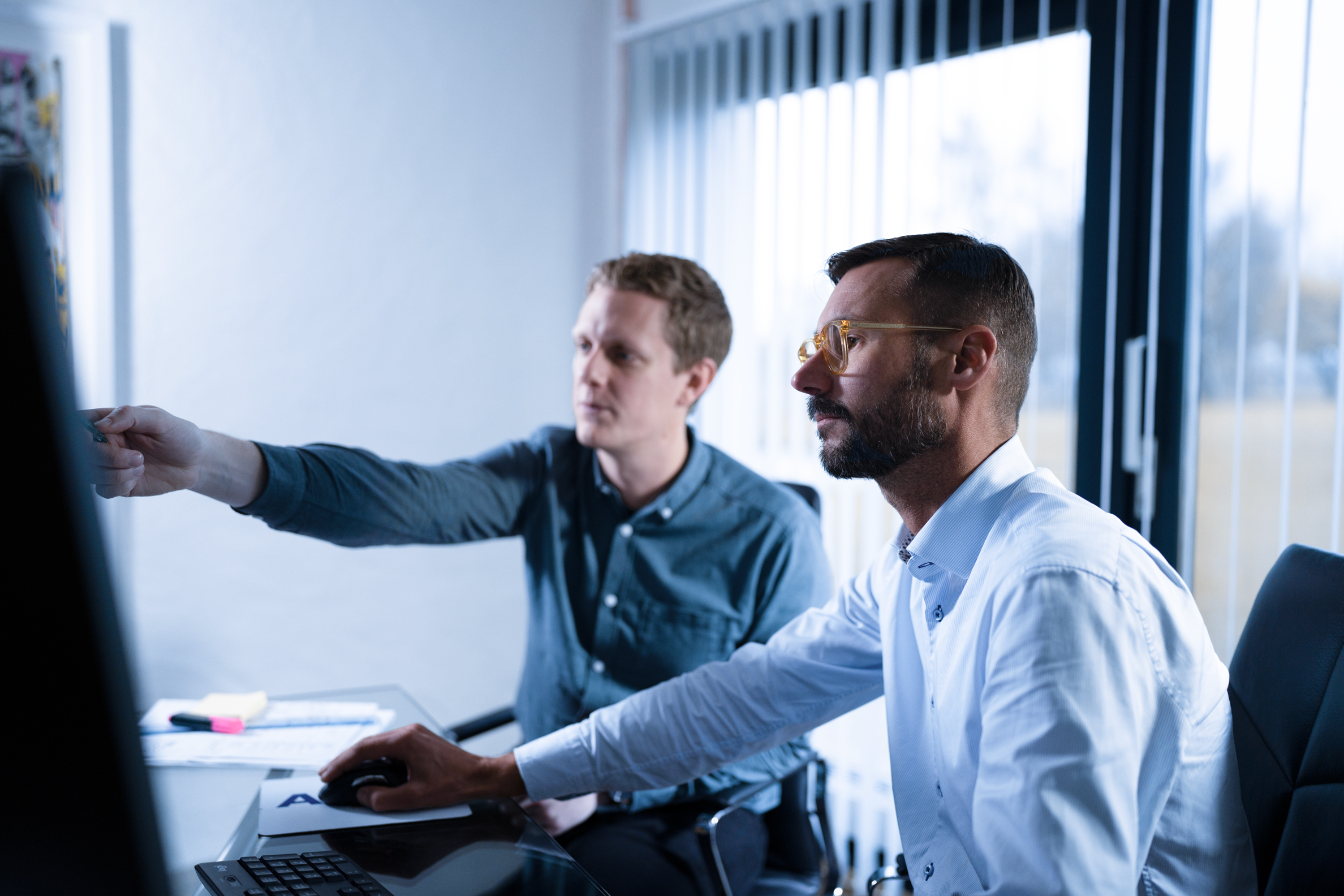 Two people working in front of a screen